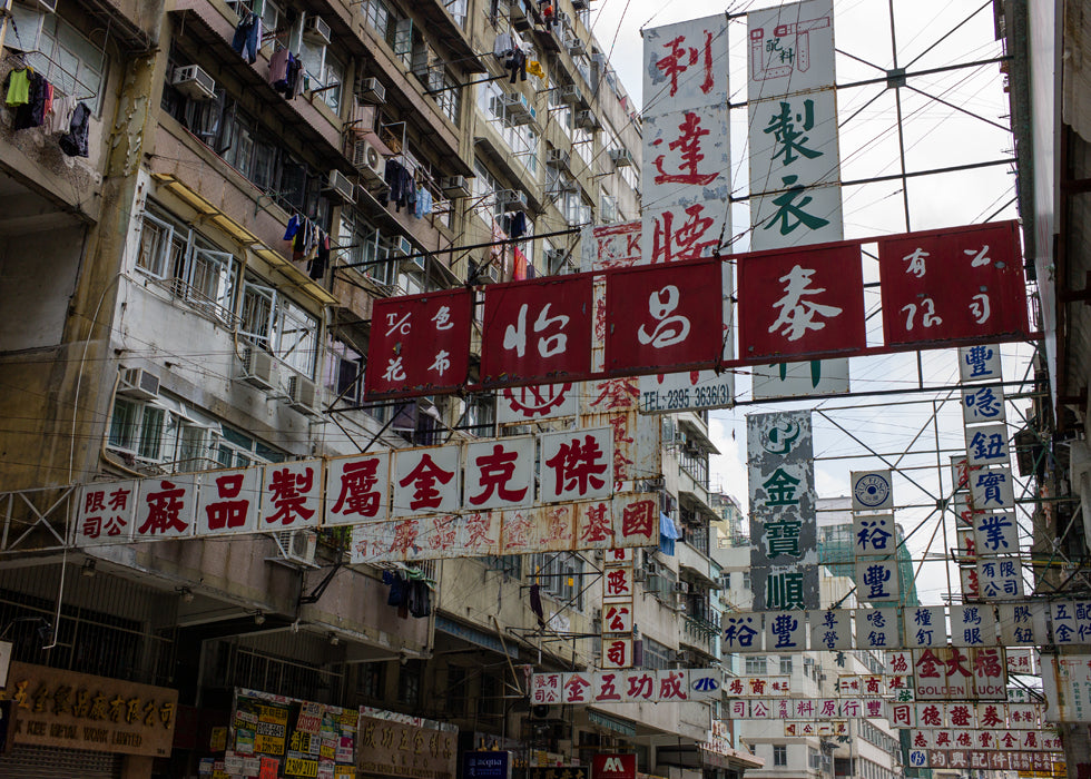 Sham Shui Po in Hong Kong, a historic garment district marked by tightly packed signage for fabric, trim, and apparel-making trades.